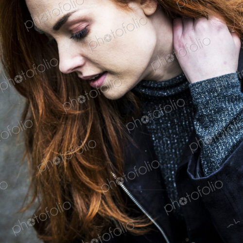 Portrait of smiling young woman with long red hair.
