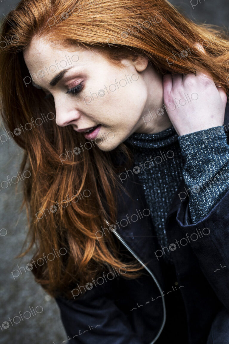 Portrait of smiling young woman with long red hair.