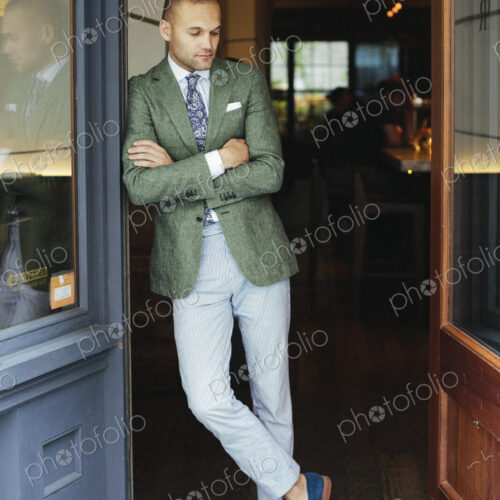 Portrait of the chef sommelier standing at the door of a city restaurant.