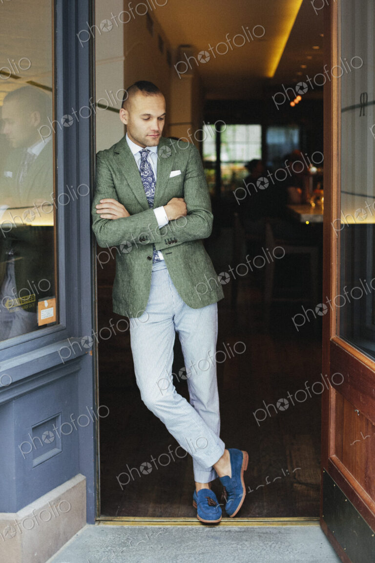 Portrait of the chef sommelier standing at the door of a city restaurant.