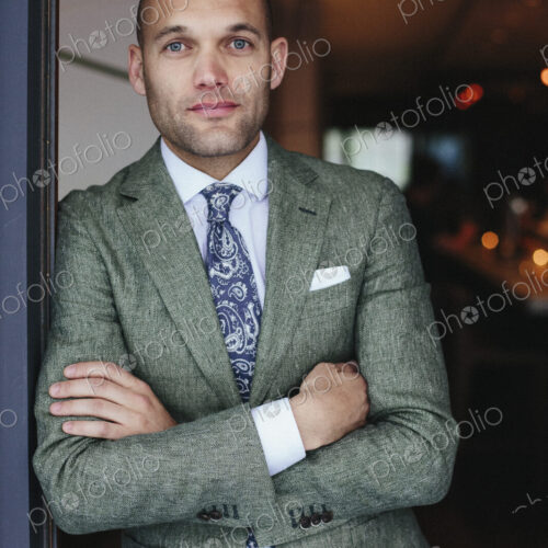Portrait of the chef sommelier standing at the door of a city restaurant.