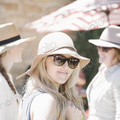 Portrait of three women wearing hats and sunglasses.