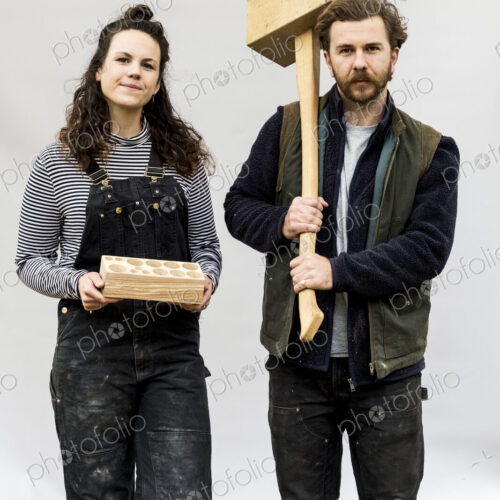 Portrait of woman and bearded man holding wooden blocks standing in front of white… Portrait of woman and bearded man holding wooden blocks standing in front of white…