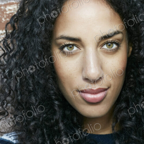 Portrait of young smiling woman with long curly black hair looking at camera. Portrait of young smiling woman with long curly black hair looking at camera.