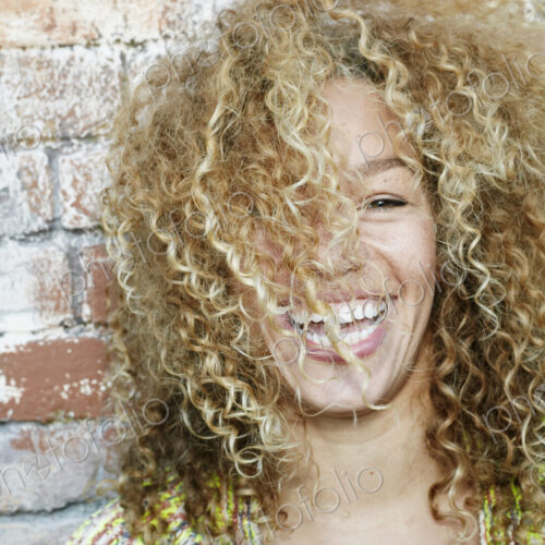 Portrait of young smiling woman with long curly blond hair, looking at camera. Portrait of young smiling woman with long curly blond hair, looking at camera.