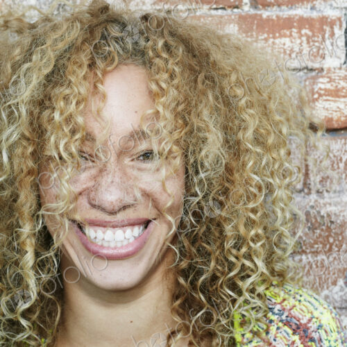 Portrait of young smiling woman with long curly blond hair, looking at camera. Portrait of young smiling woman with long curly blond hair, looking at camera.