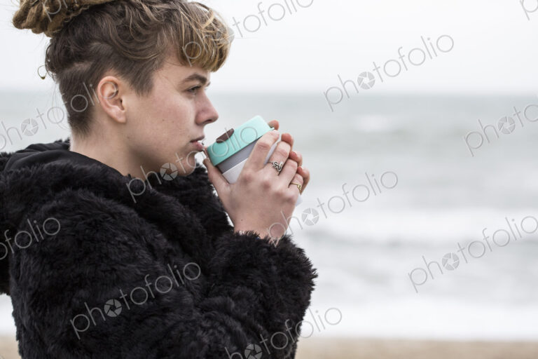 Portrait of young woman with brown hair and dreadlocks and a lip piercing wearing…