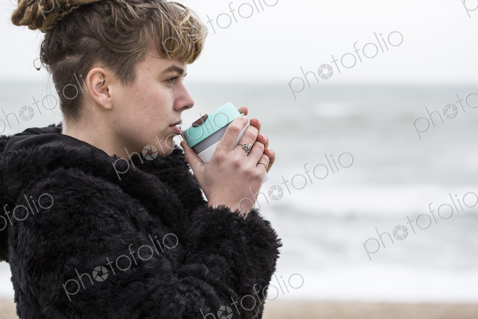 Portrait of young woman with brown hair and dreadlocks and a lip piercing wearing…