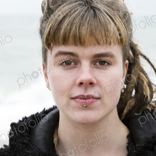 Portrait of young woman with brown hair and dreadlocks and a lip piercing wearing… Portrait of young woman with brown hair and dreadlocks and a lip piercing wearing…