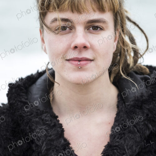 Portrait of young woman with brown hair and dreadlocks and a lip piercing wearing… Portrait of young woman with brown hair and dreadlocks and a lip piercing wearing…