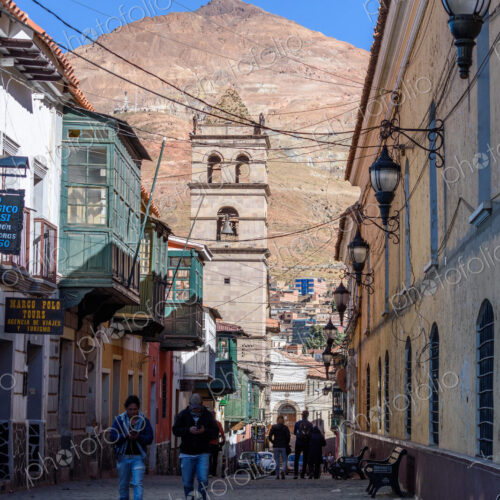 Potosi, a narrow street with a bell tower and view of Cerro Rico, the vast conical…