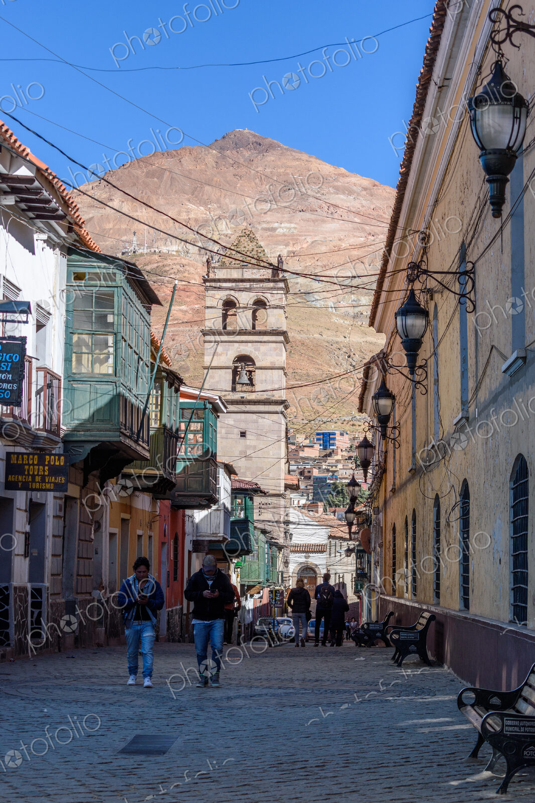 Potosi, a narrow street with a bell tower and view of Cerro Rico, the vast conical…