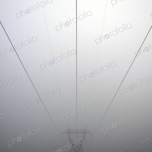 Power lines and foggy sky