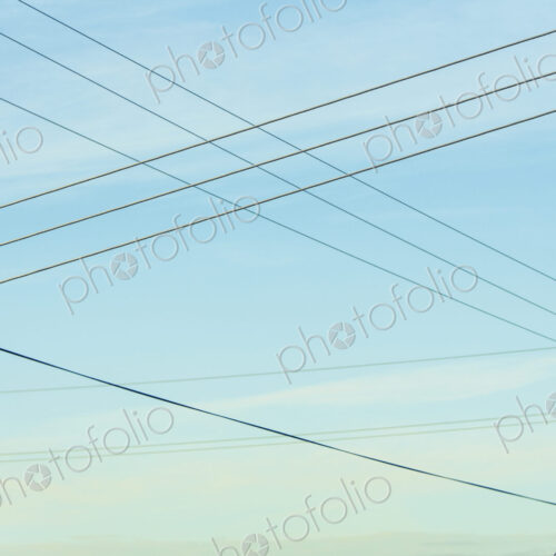 Power lines overhead, criss crossing in the air, at Belridge in California. Power lines overhead, criss crossing in the air, at Belridge in California.