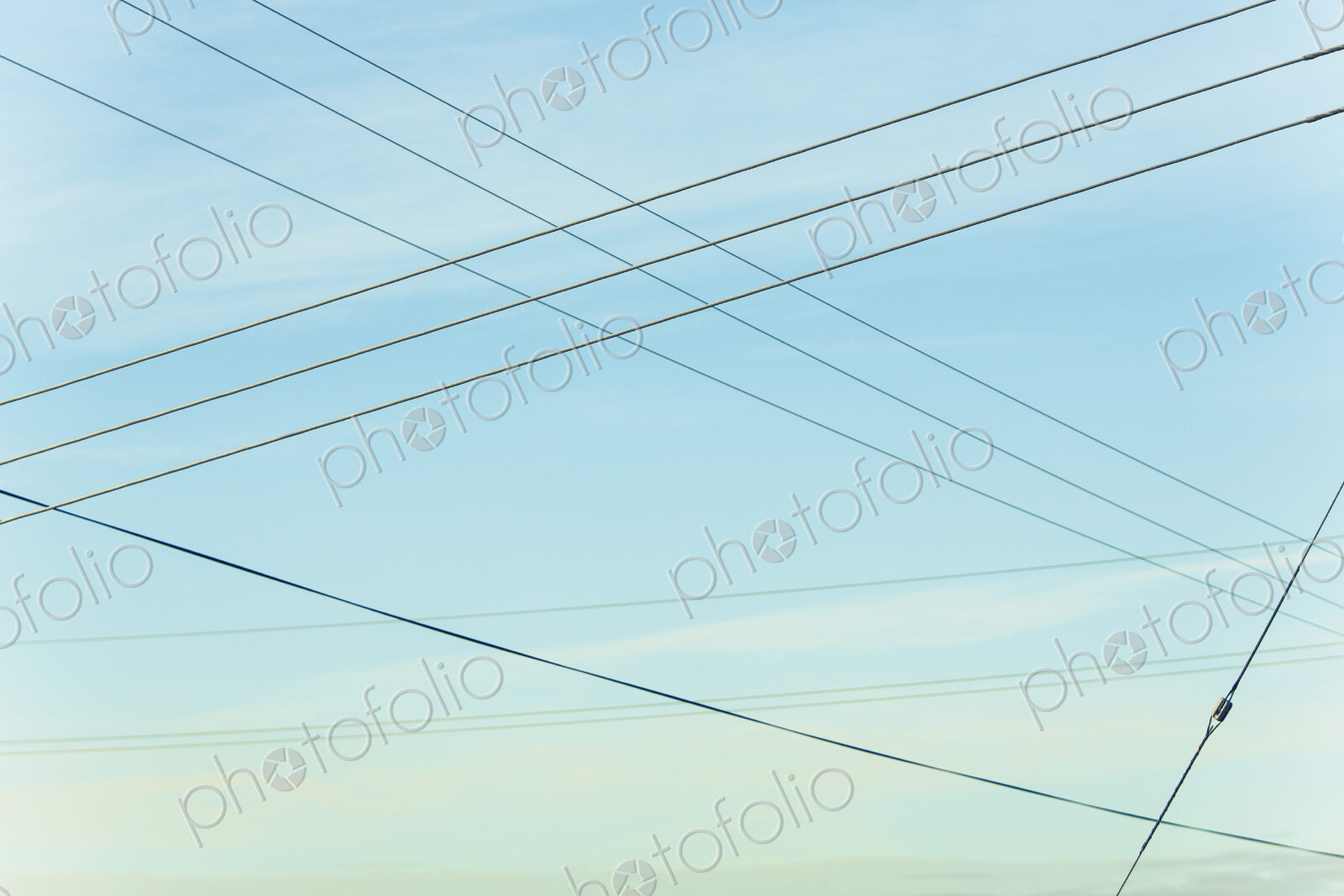 Power lines overhead, criss crossing in the air, at Belridge in California.