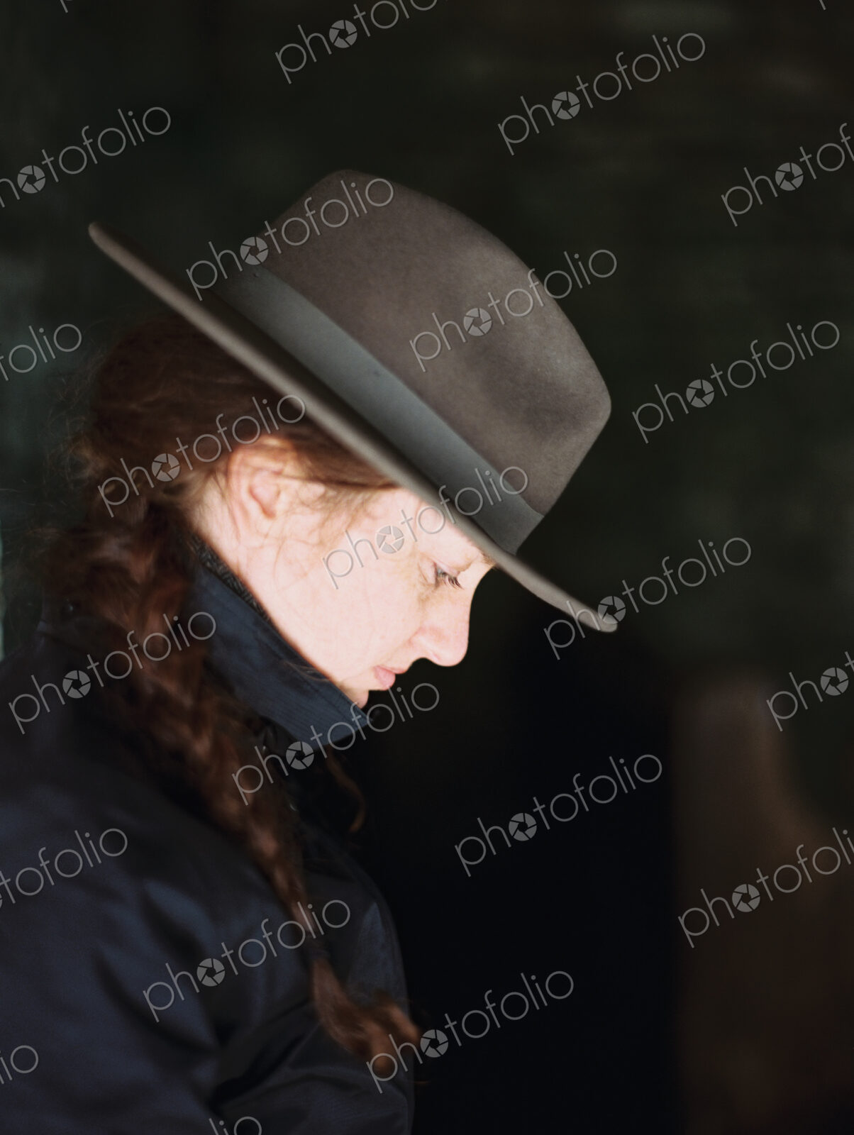 Profile of a woman wearing a felt hat with a brim.