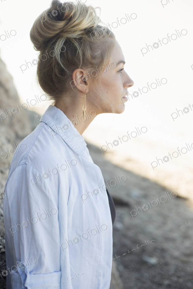 Profile portrait of a blond woman with a hair bun.