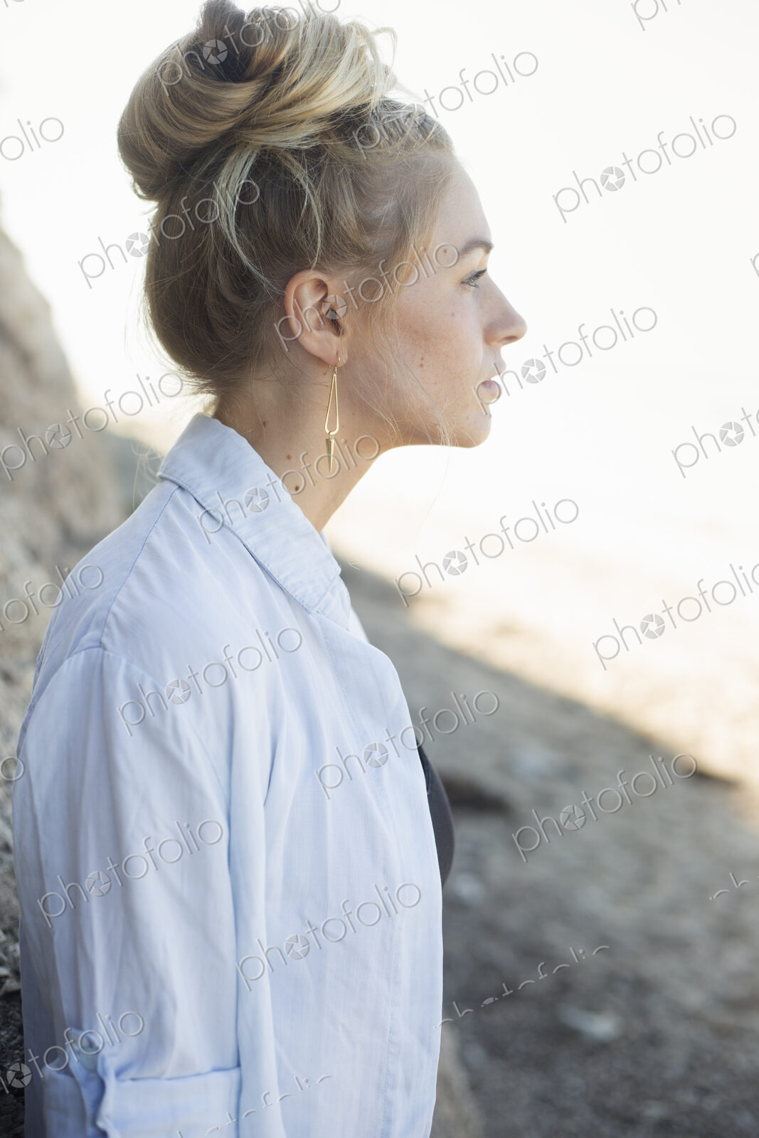 Profile portrait of a blond woman with a hair bun.