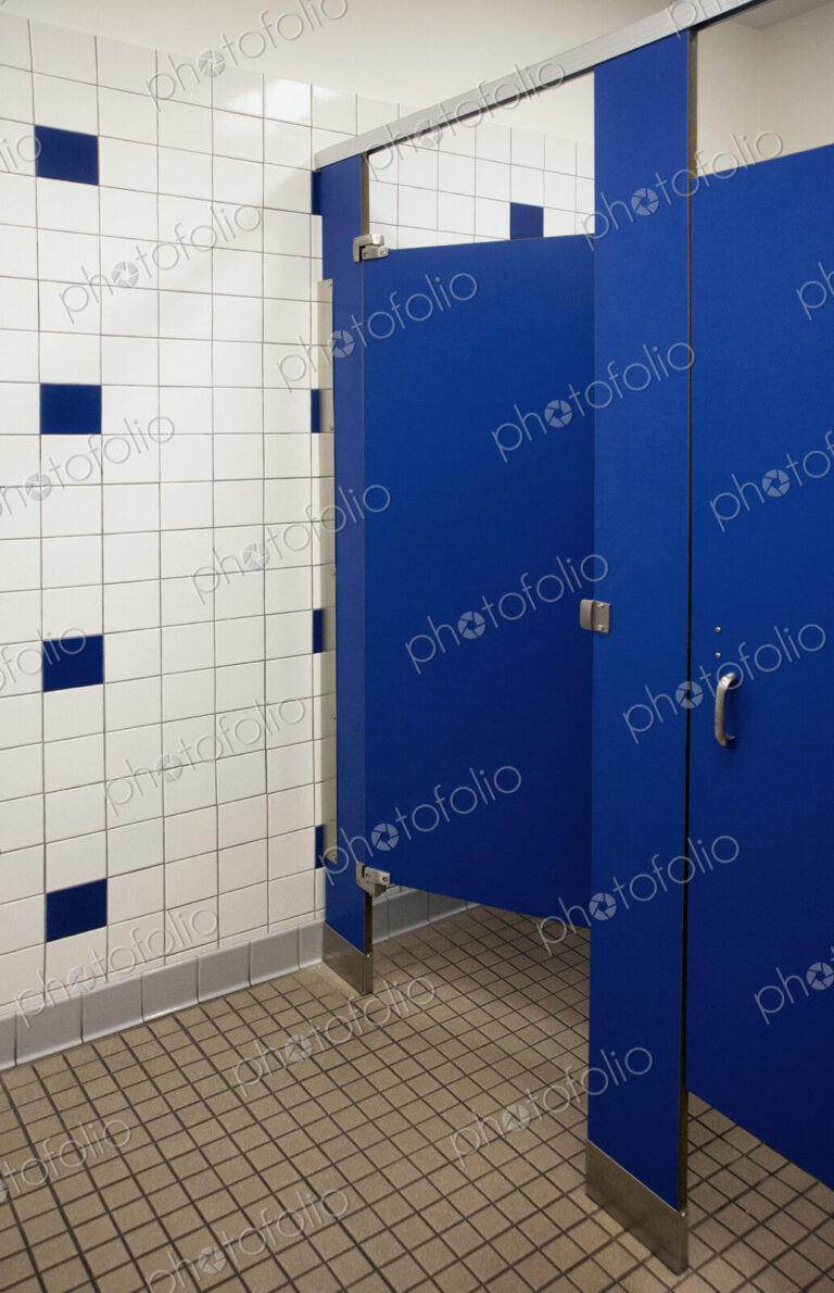 Public bathroom showers and toilet cubicles with blue doors.