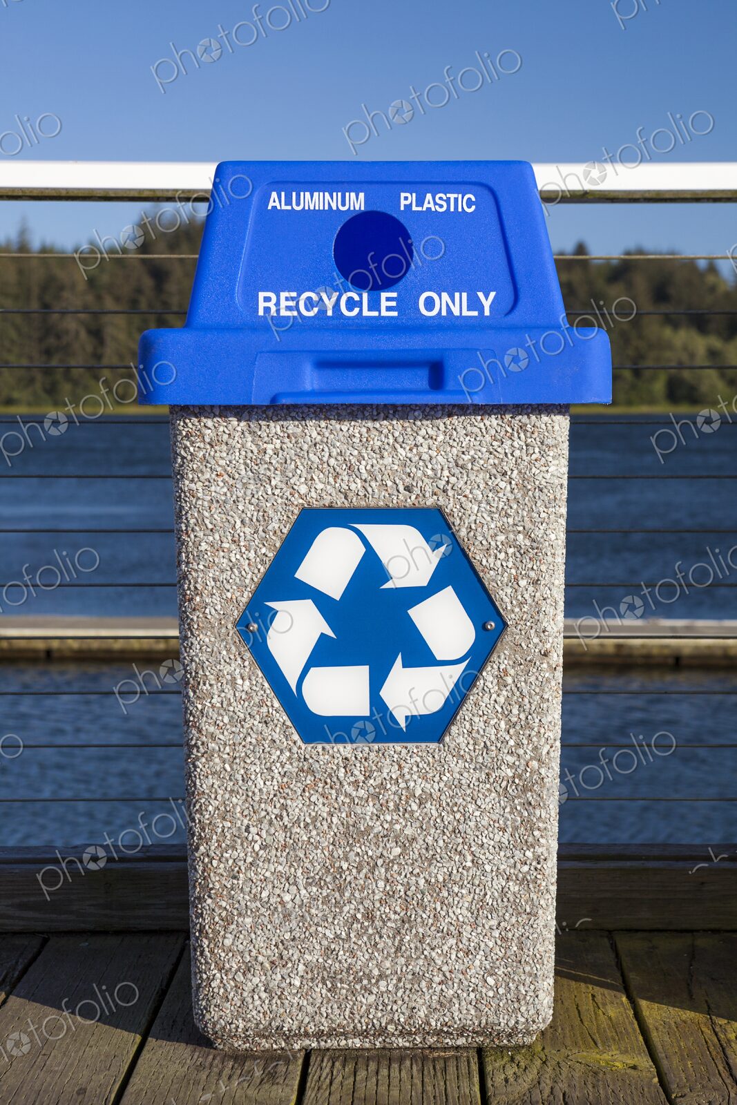 Public recycling bin with blue lid labeled for aluminum and plastic, featuring the…
