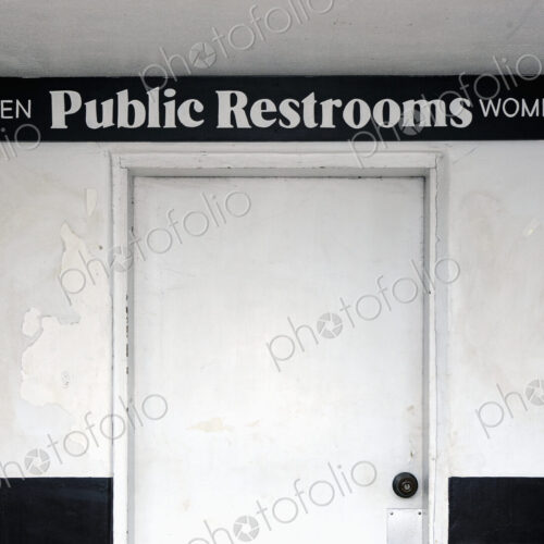 Public restrooms, sign over a white door saying Men and Women.