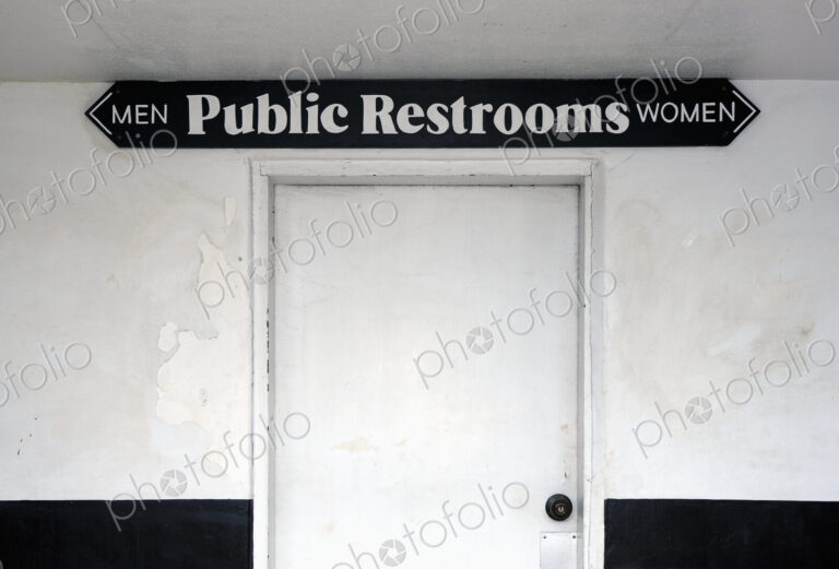Public restrooms, sign over a white door saying Men and Women.