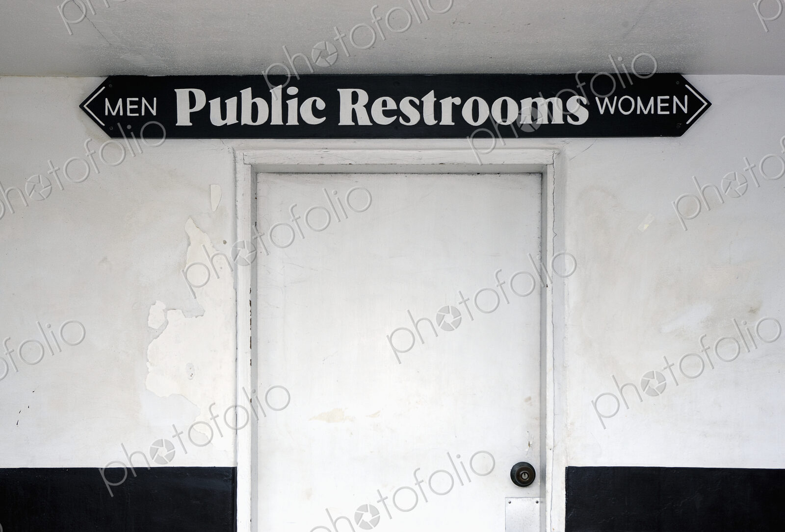 Public restrooms, sign over a white door saying Men and Women.