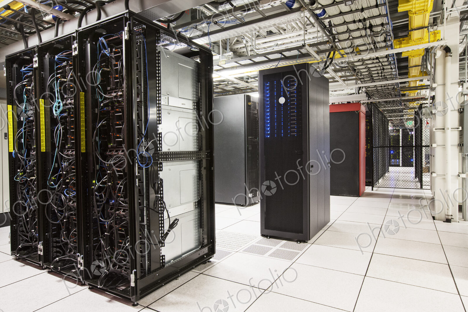 Racks of servers aligned in rows in a large computer server farm.