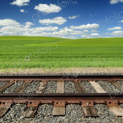 Railroad tracks and rolling hills in rural landscape