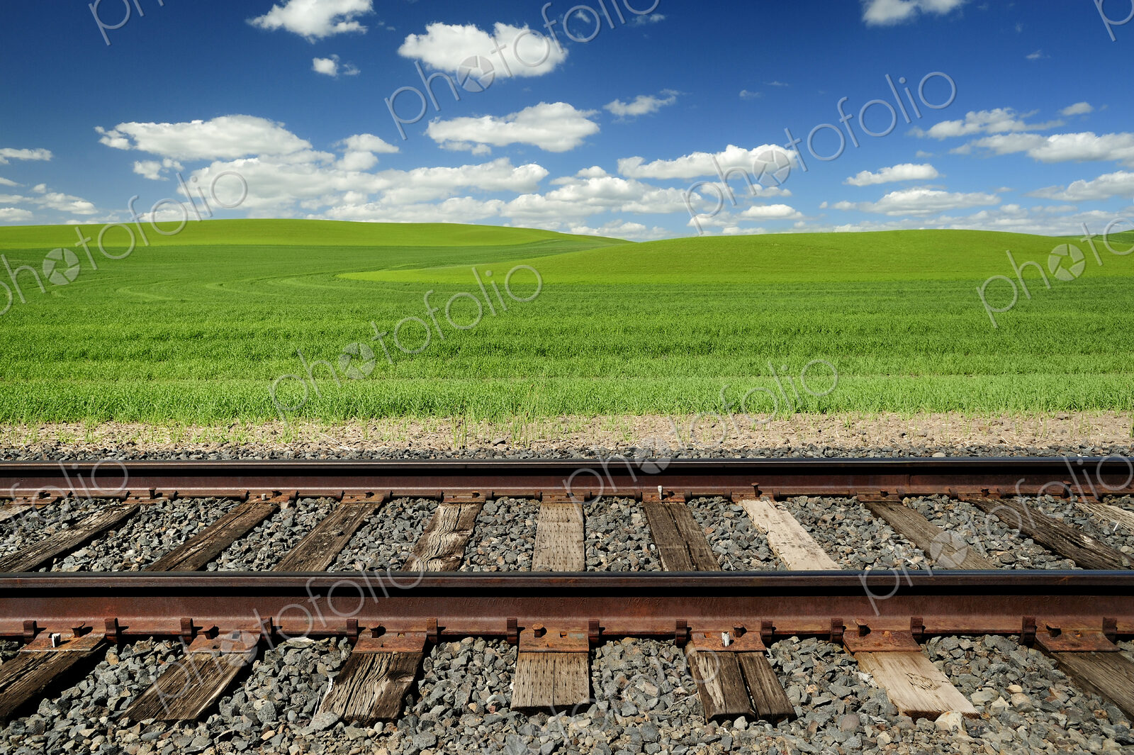 Railroad tracks and rolling hills in rural landscape