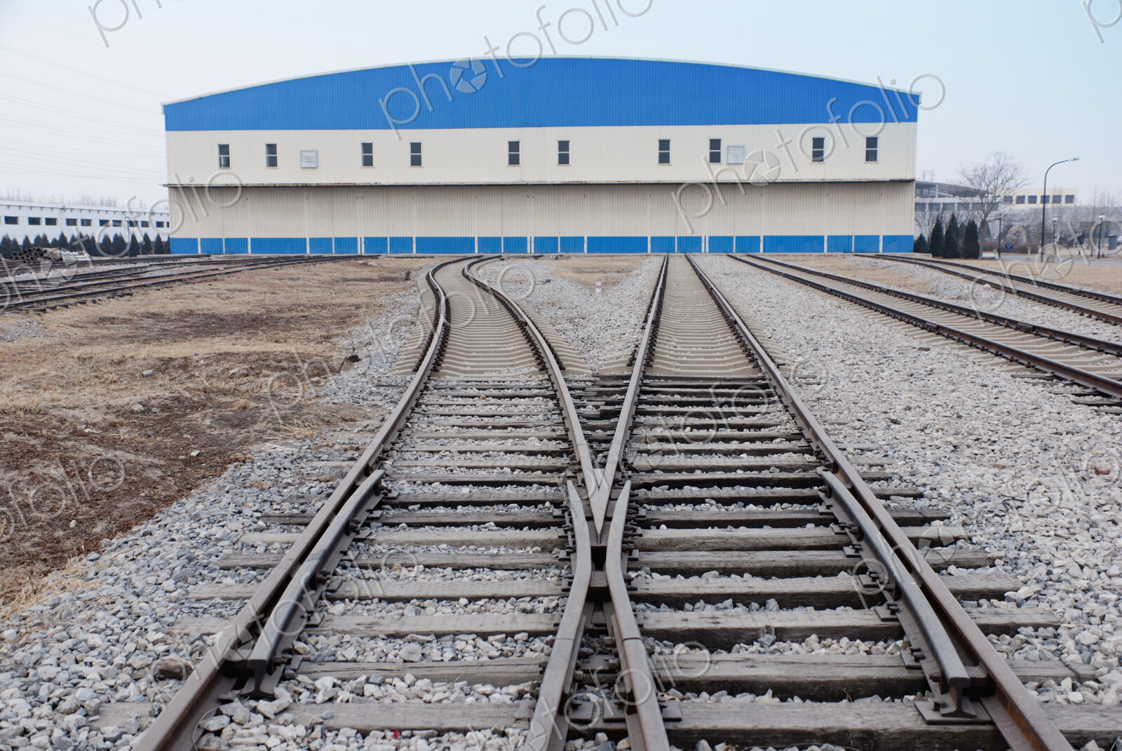 Railway shed with blue roof and sidings.