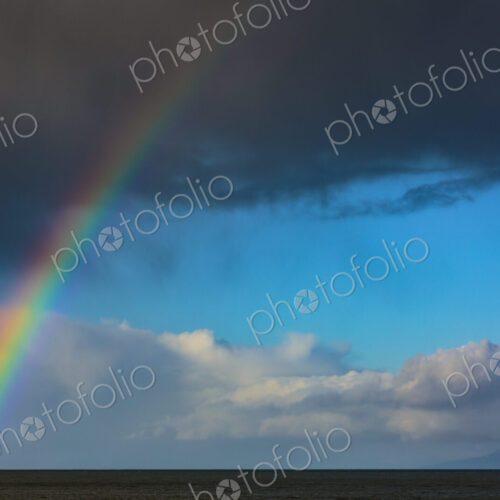 Rainbow over water with dark storm clouds on the Strait of Juan de Fuca, Port Angeles