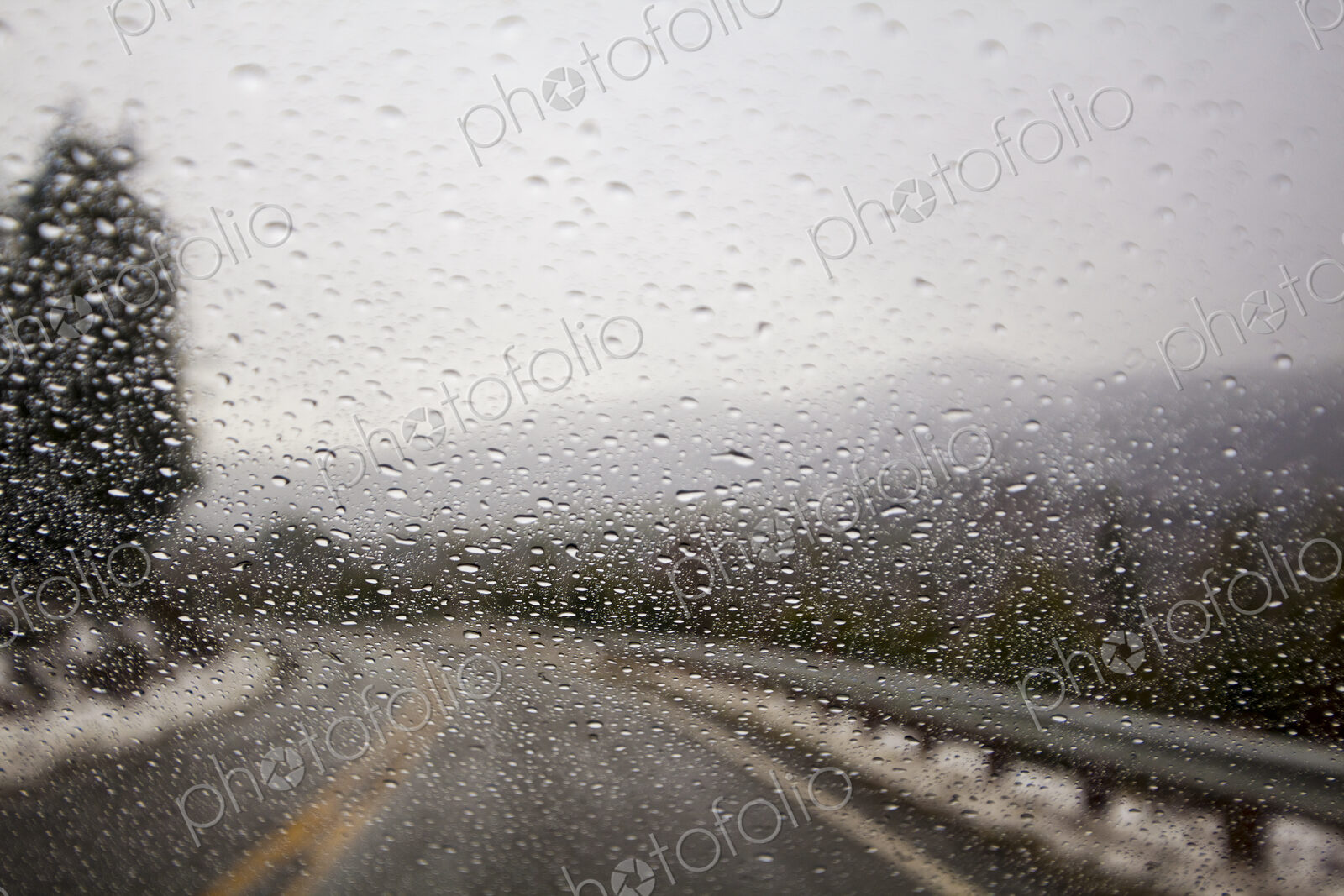 Raindrops on windshield on two lane highway.
