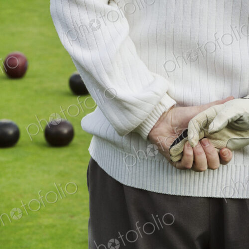 Rear view, a man standing with his hands clasped behind him, one hand in a playing… Rear view, a man standing with his hands clasped behind him, one hand in a playing…