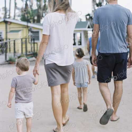 Rear view of a family, a couple walking with their young son and daughter.