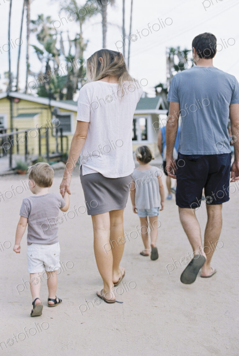 Rear view of a family, a couple walking with their young son and daughter.