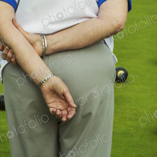 Rear view of a woman lawn bowls player with hands behind her back, and lawn bowls… Rear view of a woman lawn bowls player with hands behind her back, and lawn bowls…