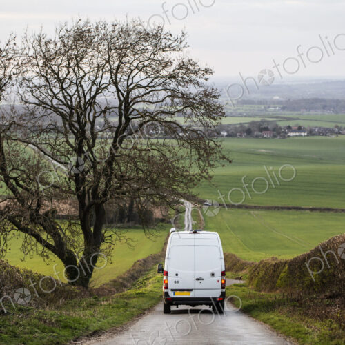 Rear view of camper van driving down a country lane. Rear view of camper van driving down a country lane.