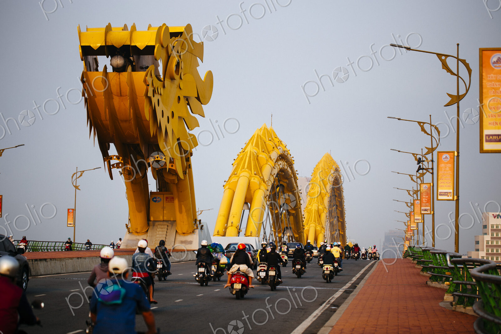 Rear view of commuters on motorcycles crossing bridge in the shape of a dragon.