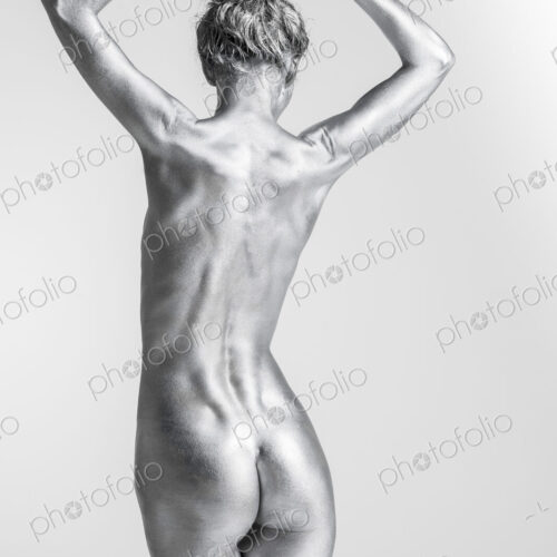 Rear view of nude Caucasian woman with silver body paint Rear view of nude Caucasian woman with silver body paint