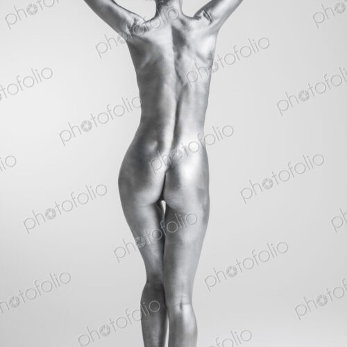 Rear view of nude Caucasian woman with silver body paint Rear view of nude Caucasian woman with silver body paint