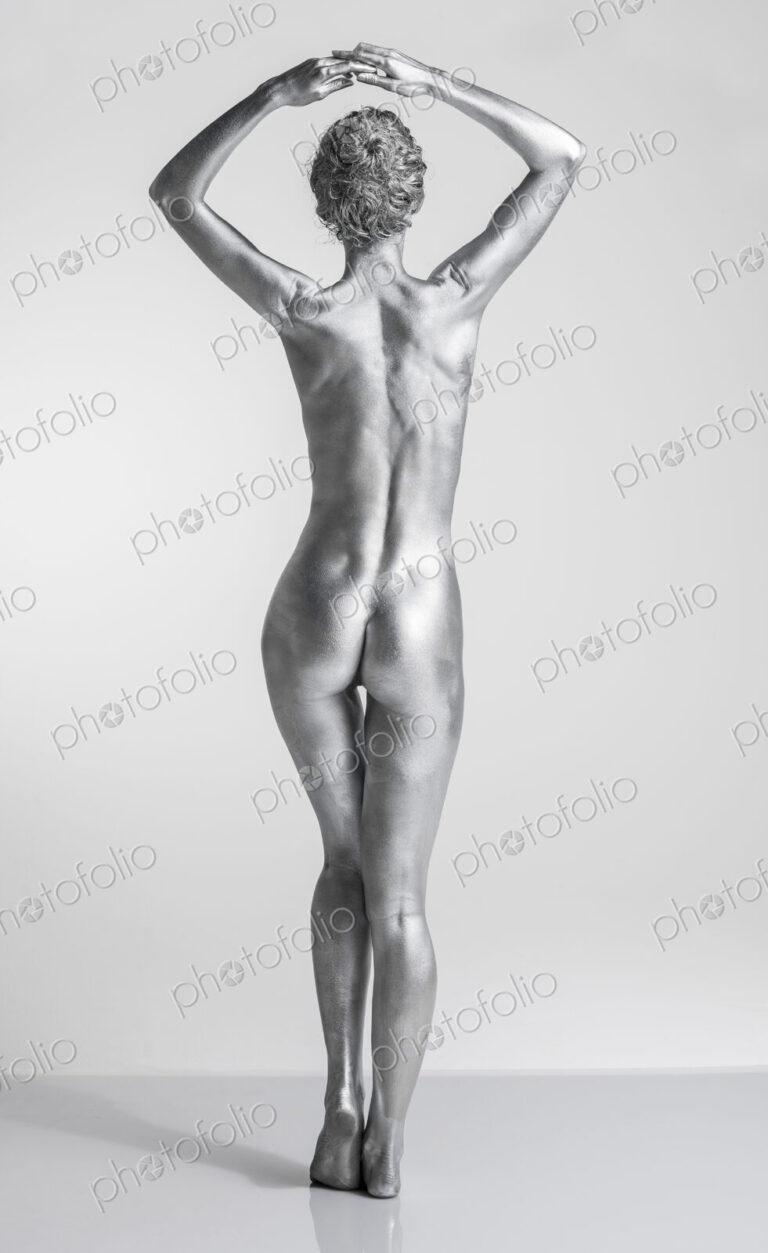 Rear view of nude Caucasian woman with silver body paint