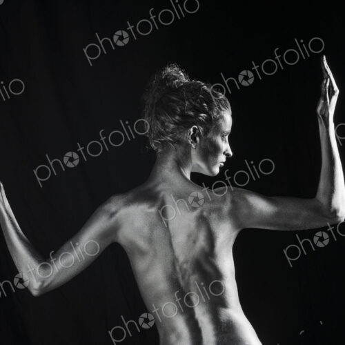 Rear view of nude Caucasian woman with silver body paint Rear view of nude Caucasian woman with silver body paint