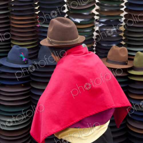 Rear view of woman selling traditional Ecuadorian felt hats.