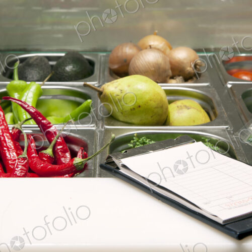 Receipts booklet on the counter of a fresh ingredients display.