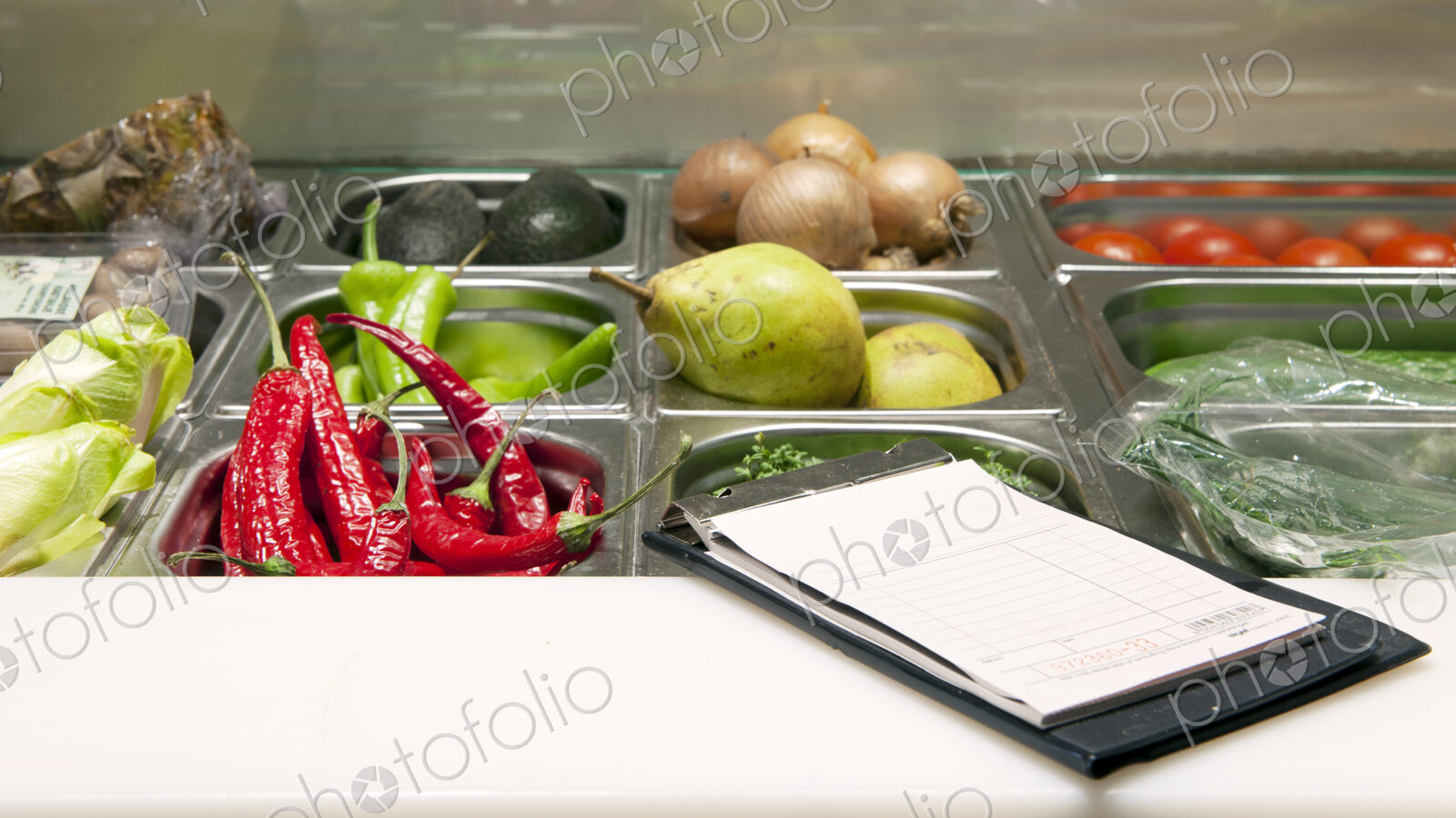 Receipts booklet on the counter of a fresh ingredients display.