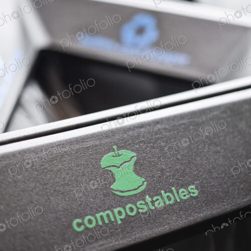 Recycle bin in a hallway, dividing into sections for compostable food waste and…
