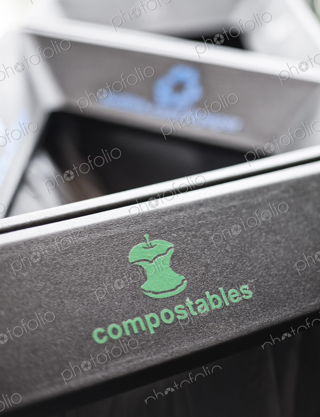 Recycle bin in a hallway, dividing into sections for compostable food waste and…