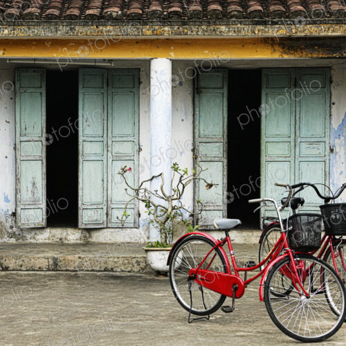 Red Bikes Parked in Front of a Weathered Building Red Bikes Parked in Front of a Weathered Building