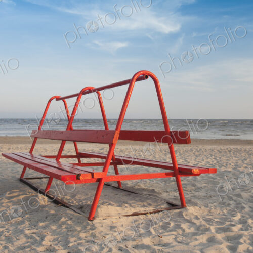 Red Park Bench on the Beach